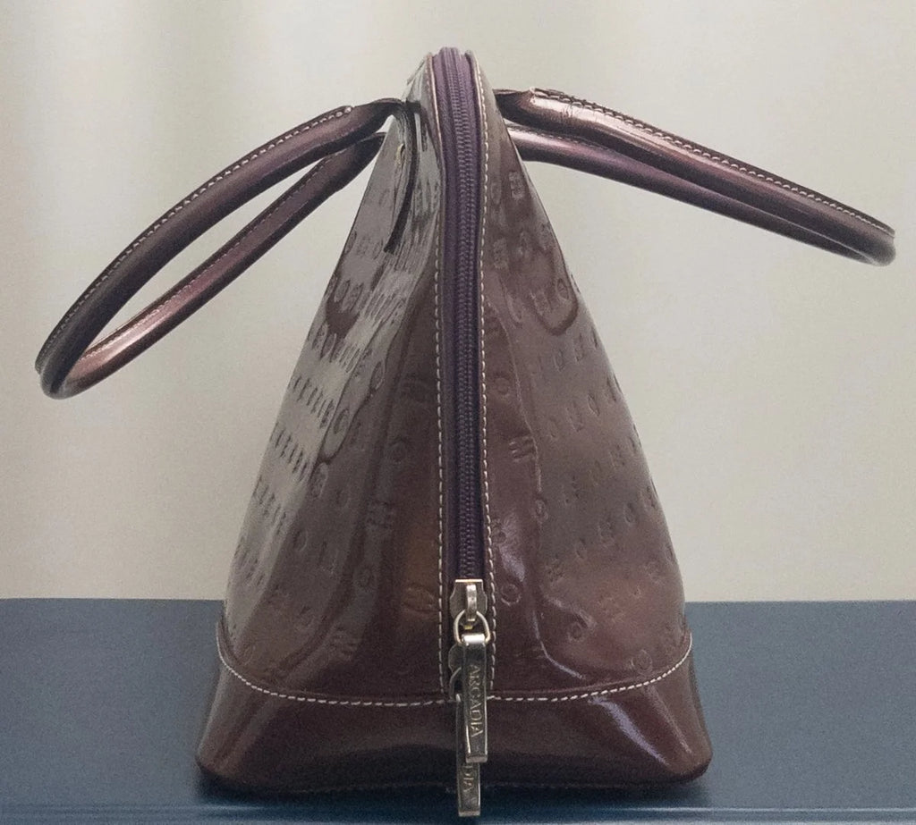 A brown Louis Vuitton shoulder bag with a glossy embossed pattern, featuring dual top handles and a front zipper closure, displayed on a dark surface against a light background.